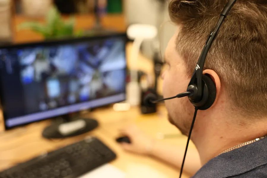 ARGUS operator with a headset monitoring CCTV feeds in the control room