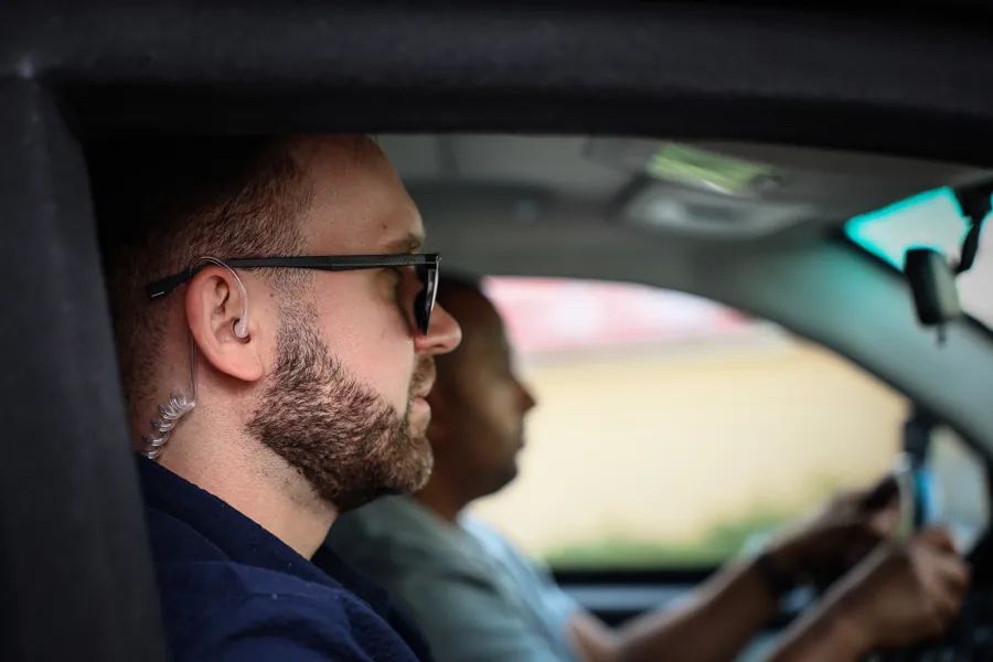 ARGUS close protection driver at the wheel with a client in the back seat
