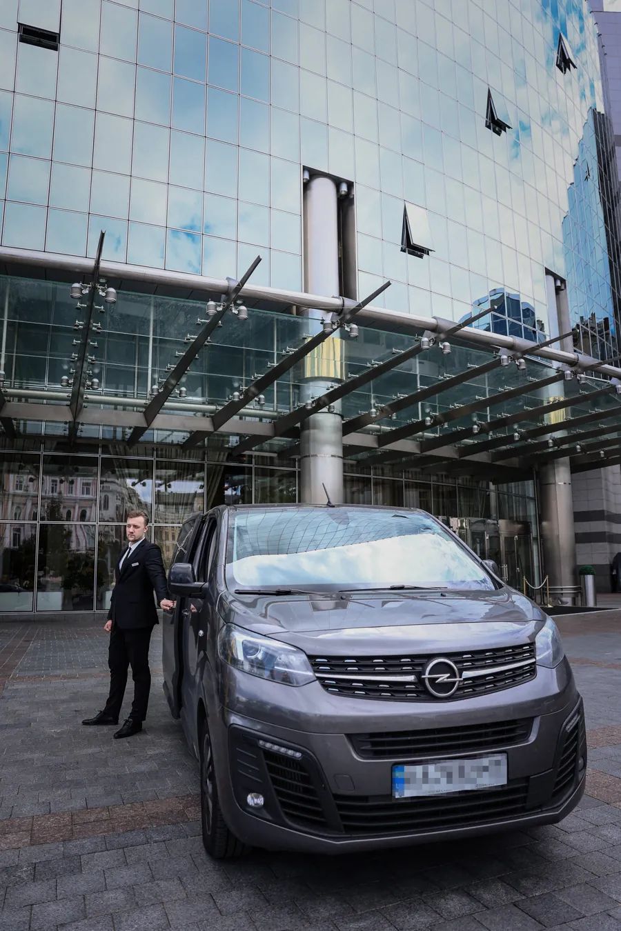 ARGUS shuttle van and driver waiting outside a hotel entrance